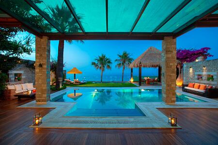 Outdoor decking and pool area of a royal spa villa at dusk